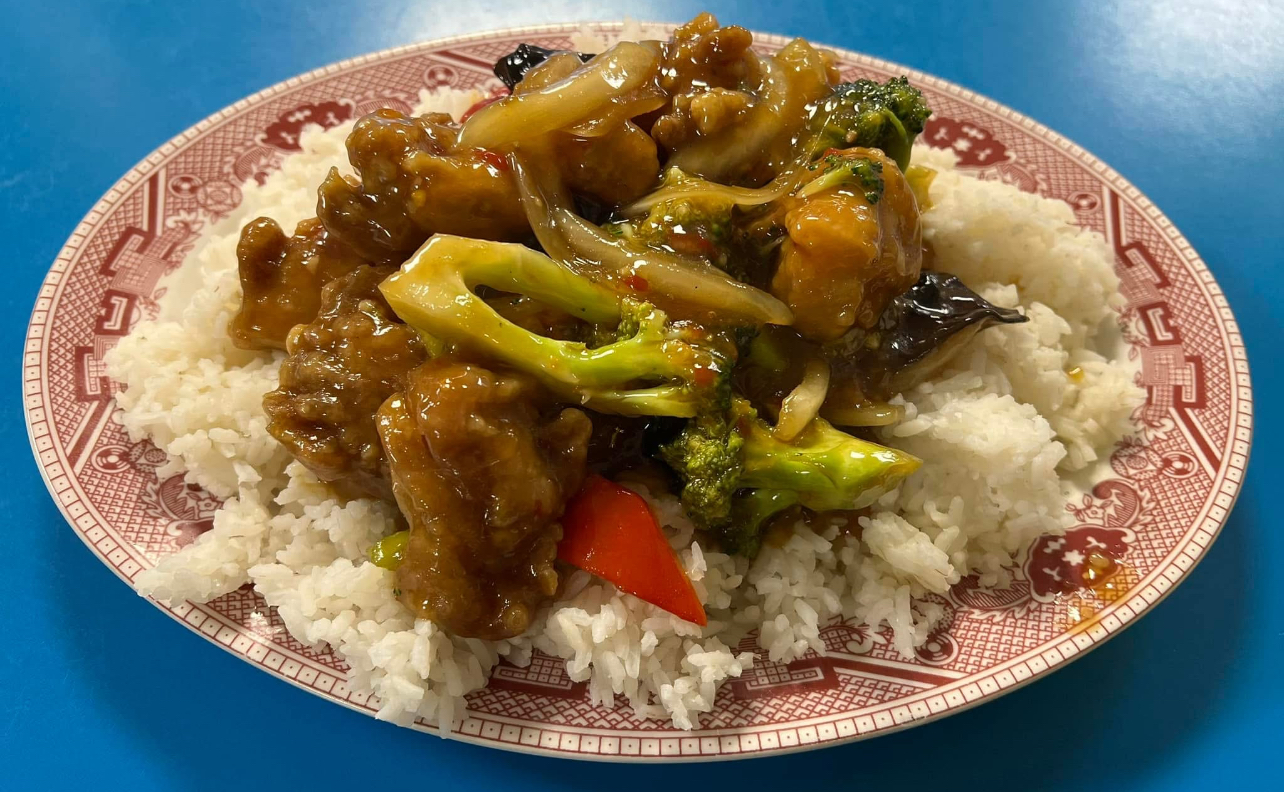 Beef and broccoli over rice on the classic red plate at Wo Hop